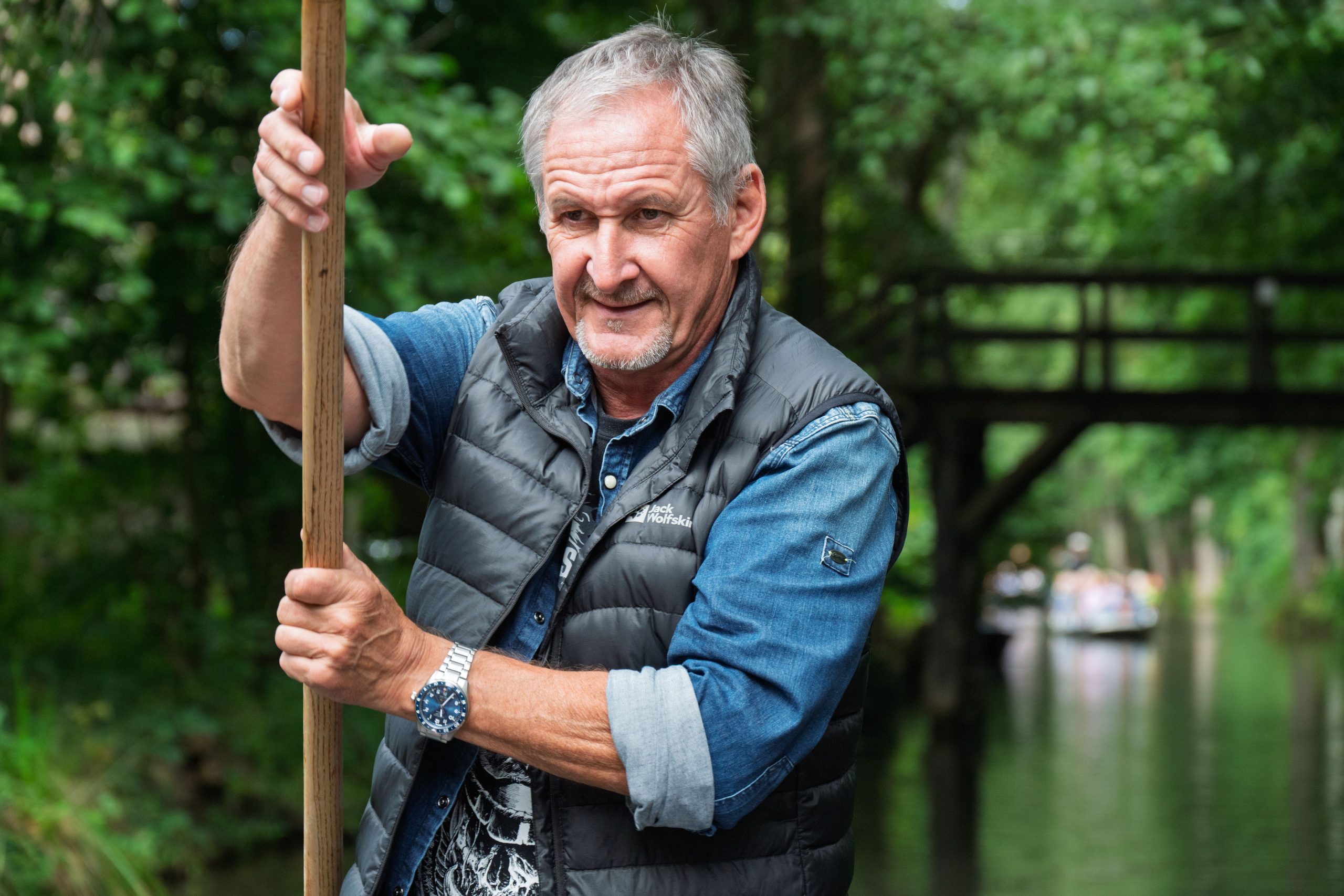 Mann mit einem Holzpaddel am Wasser in Lübbenau