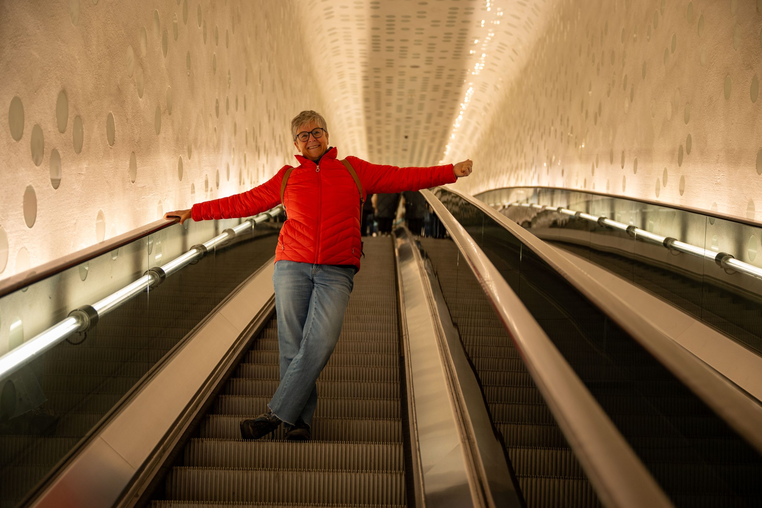 Person in roter Jacke auf einer Rolltreppe in Hamburg